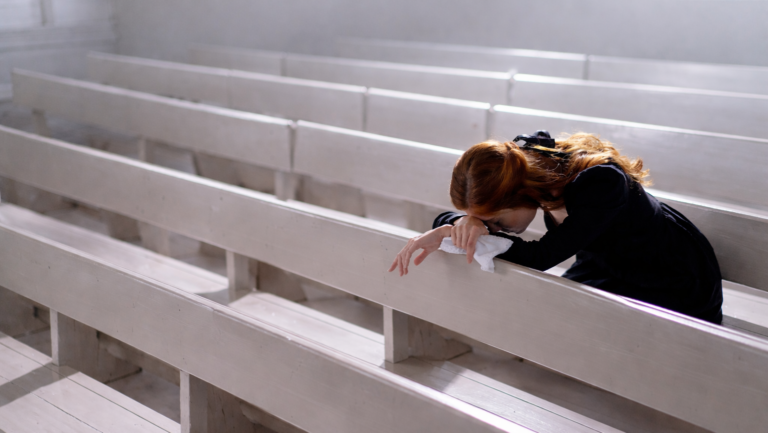 Femme en prière dans une salle de culte vide